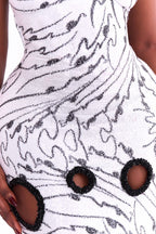 White dress with black abstract pattern and embellishments on a person